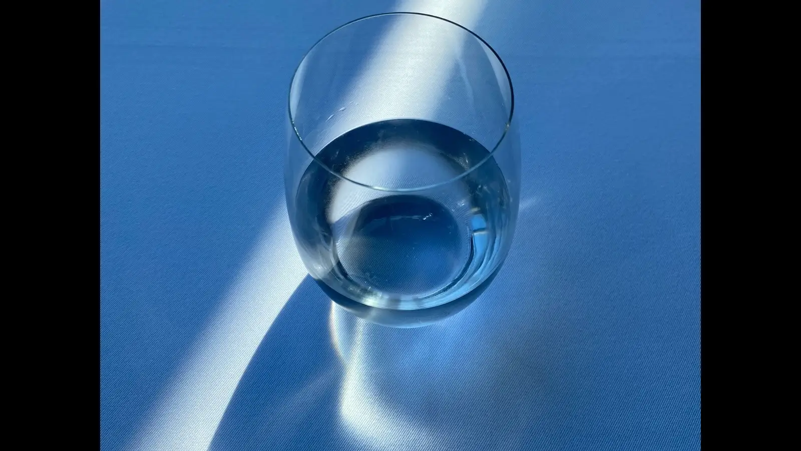 A glass of water sitting on a table.