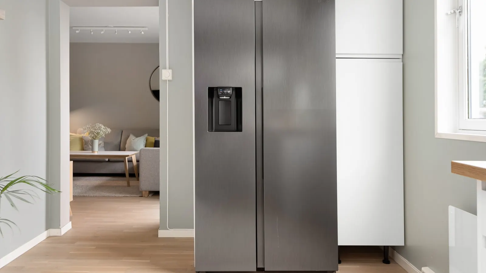 A refrigerator light spilling into a dark kitchen at night.